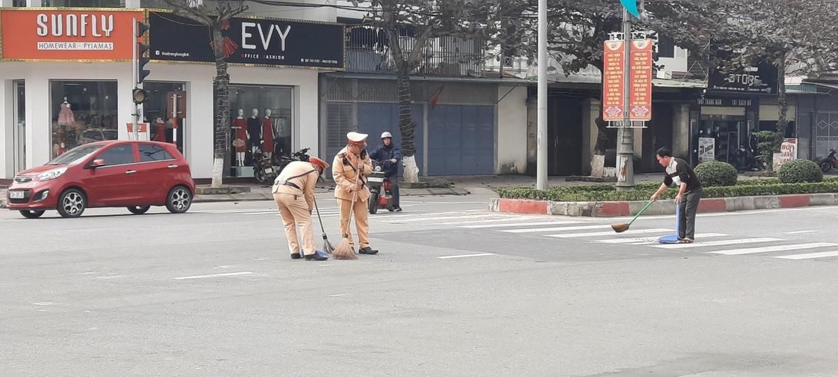 Hình ảnh đẹp của Cảnh sát giao thông – Công an thị xã Hồng Lĩnh dùng chổi dọn sạch đường do cát rơi vãi